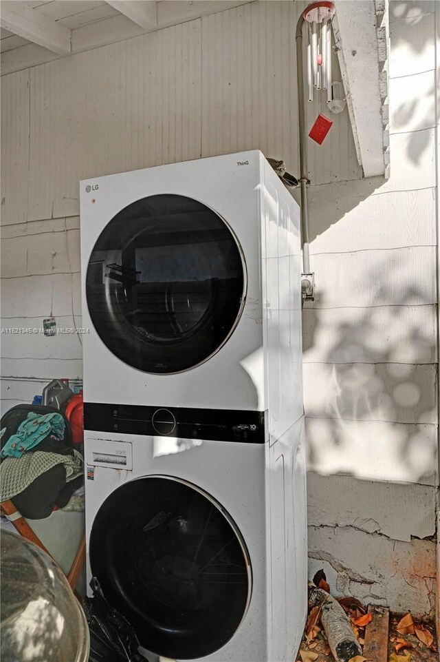 washroom featuring stacked washer / drying machine