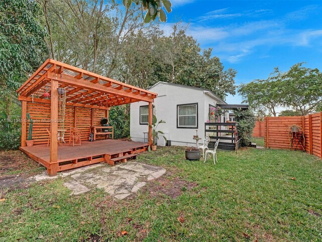 back of house with a wooden deck, a lawn, and a pergola