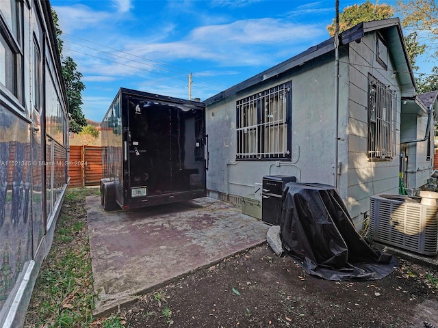 back of property featuring central AC unit and a patio