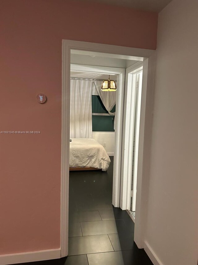 hallway with dark tile patterned floors