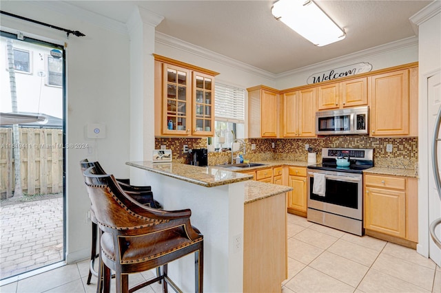 kitchen featuring stainless steel appliances, backsplash, light tile patterned floors, and kitchen peninsula