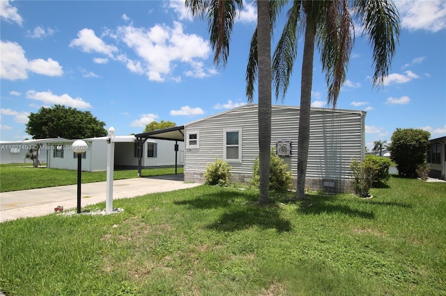 exterior space with a carport and a lawn