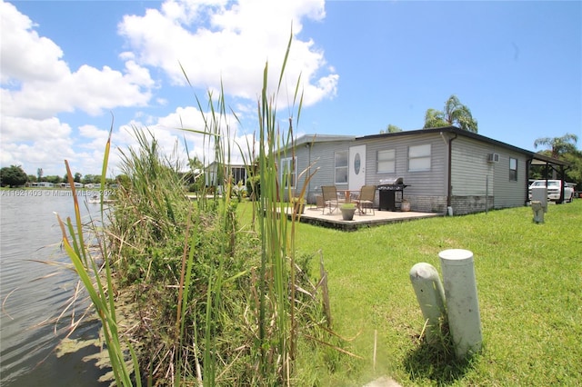 exterior space with a patio, a water view, and a yard