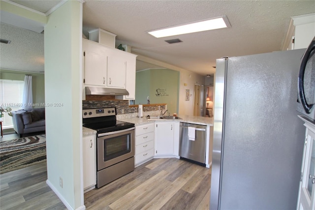 kitchen featuring white cabinetry, sink, backsplash, stainless steel appliances, and a textured ceiling