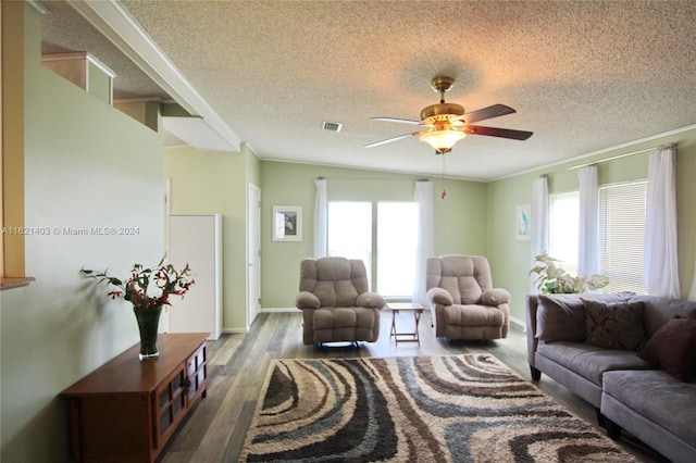 living room featuring ceiling fan, wood-type flooring, a textured ceiling, and ornamental molding