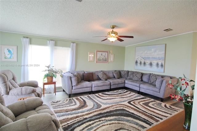 living room featuring crown molding, wood-type flooring, and a textured ceiling