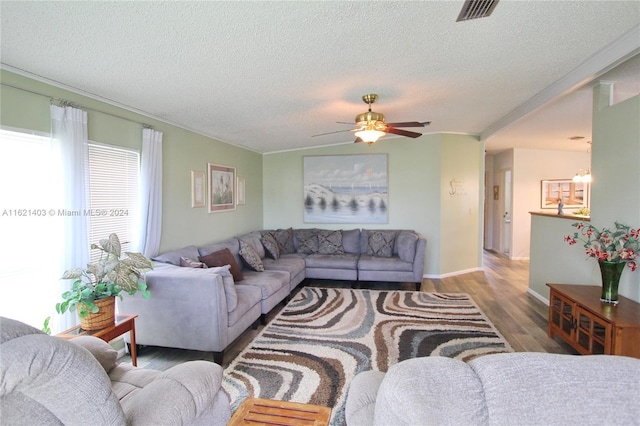 living room with ceiling fan, dark hardwood / wood-style floors, and a textured ceiling