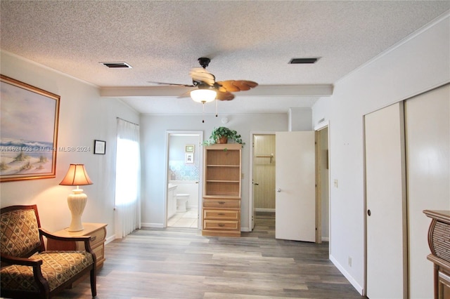 sitting room featuring hardwood / wood-style floors, crown molding, a textured ceiling, and ceiling fan