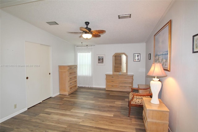 sitting room with ceiling fan, lofted ceiling, dark hardwood / wood-style floors, and a textured ceiling