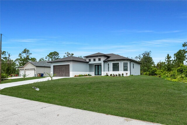 prairie-style house featuring a front lawn and a garage