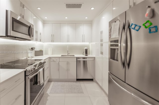 kitchen with white cabinetry, appliances with stainless steel finishes, sink, and light tile patterned flooring