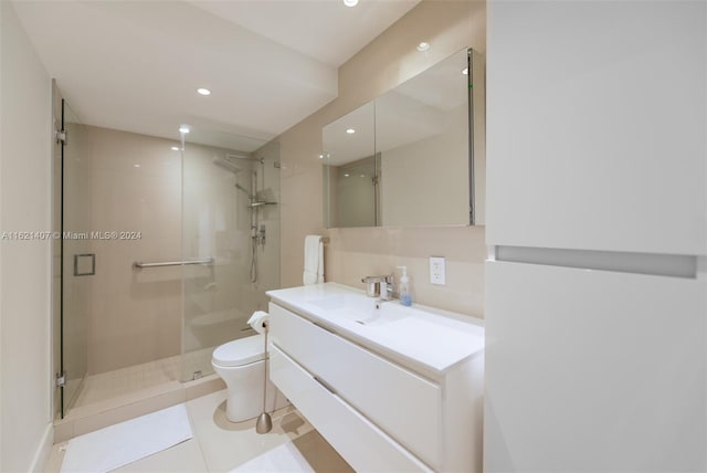 bathroom with vanity, tile patterned flooring, a shower with shower door, and toilet