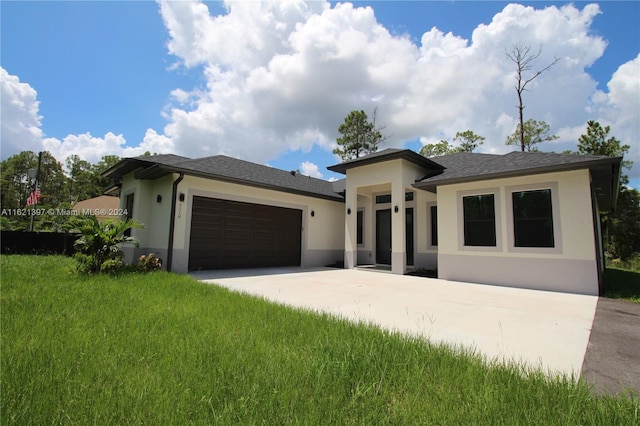 prairie-style home with a garage and a front lawn