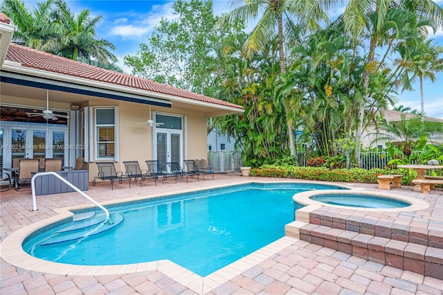 view of swimming pool with ceiling fan, french doors, a patio, and an in ground hot tub