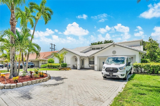 view of front of property with a garage and a front lawn