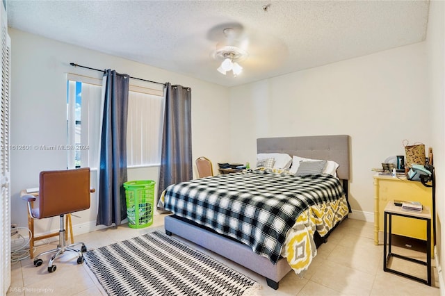 tiled bedroom with a textured ceiling and ceiling fan