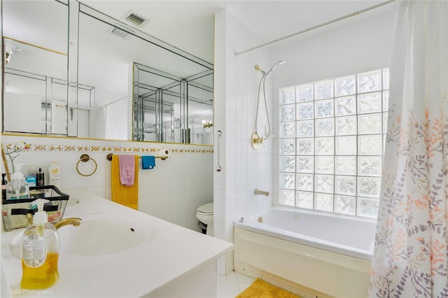 full bathroom featuring shower / bath combo with shower curtain, tile walls, tile patterned flooring, toilet, and vanity