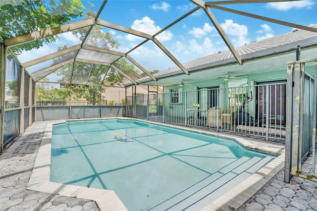 view of swimming pool with glass enclosure, a patio area, and ceiling fan