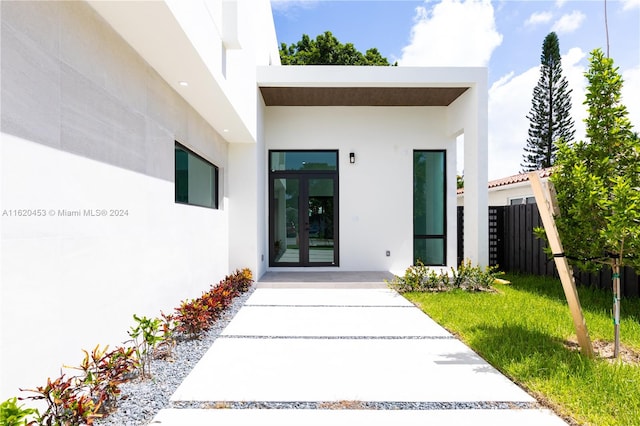 entrance to property featuring french doors and a yard