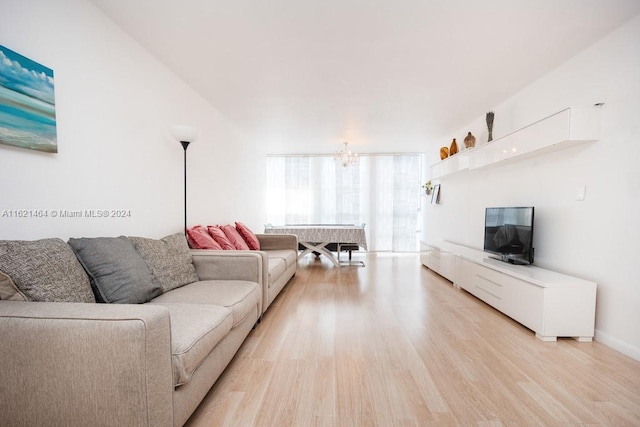 living area featuring a notable chandelier and light wood-style flooring