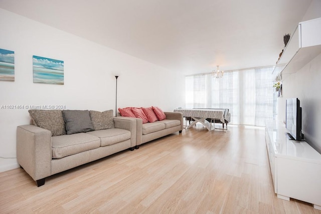 living room featuring light wood-style flooring and an inviting chandelier