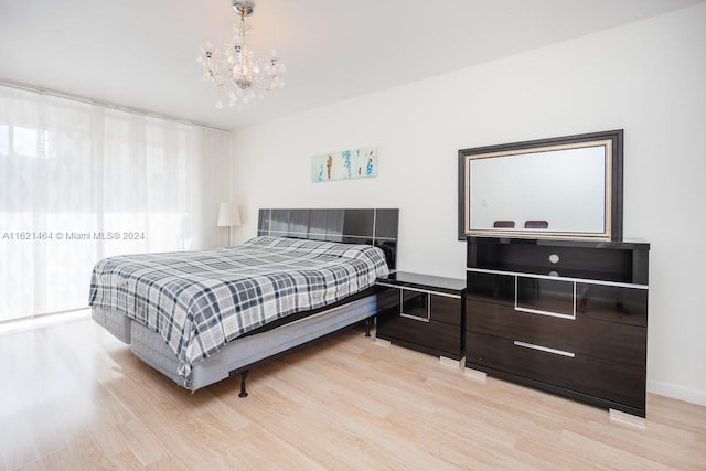 bedroom with a chandelier and light wood finished floors