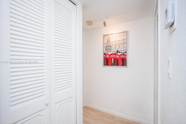 hall featuring light wood-style floors and baseboards