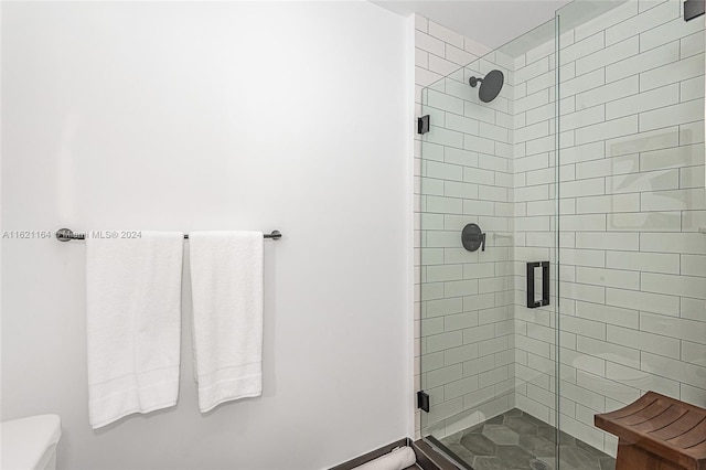 bathroom featuring toilet and an enclosed shower