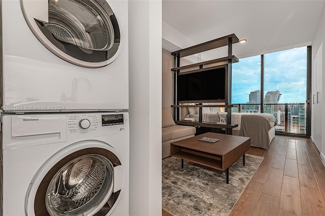 interior space with wood-type flooring and stacked washing maching and dryer