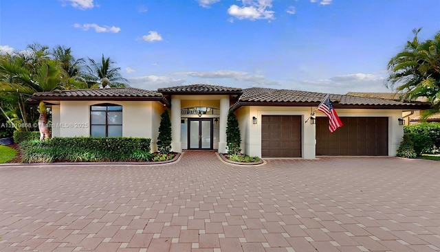 mediterranean / spanish home featuring a garage and french doors