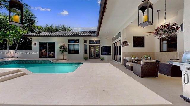 pool at dusk with a patio area and an outdoor hangout area