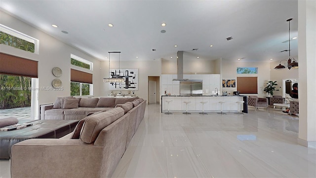 living room featuring sink, a towering ceiling, and light tile patterned floors