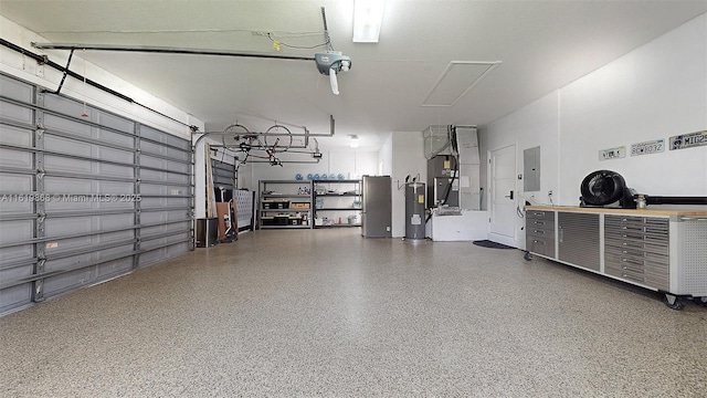 garage with heating unit, a garage door opener, electric panel, and water heater