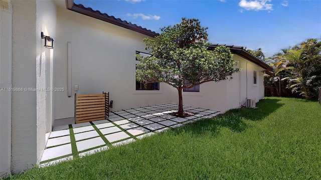 view of home's exterior with central AC unit, a patio area, and a yard