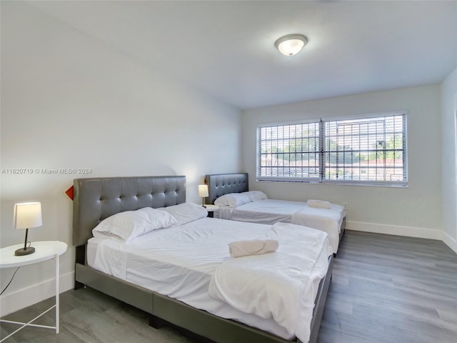 bedroom with dark hardwood / wood-style flooring