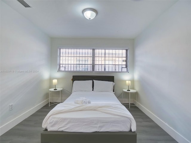 bedroom with dark wood-type flooring