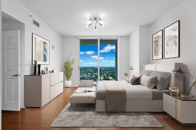 bedroom featuring access to outside, hardwood / wood-style flooring, and floor to ceiling windows