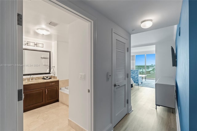 hallway with sink and light hardwood / wood-style flooring