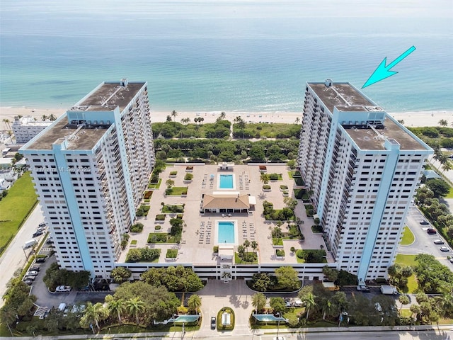 birds eye view of property featuring a water view and a beach view