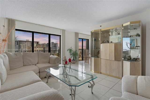 living room with a view of city, a textured ceiling, and light tile patterned floors