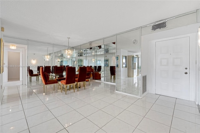 unfurnished dining area with visible vents, a textured ceiling, and light tile patterned flooring