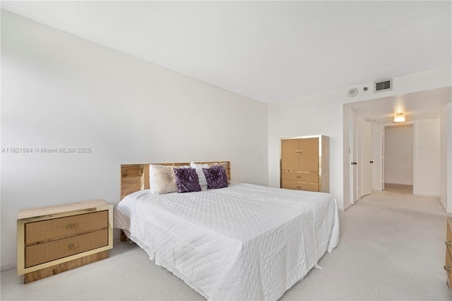 bedroom featuring visible vents and light carpet