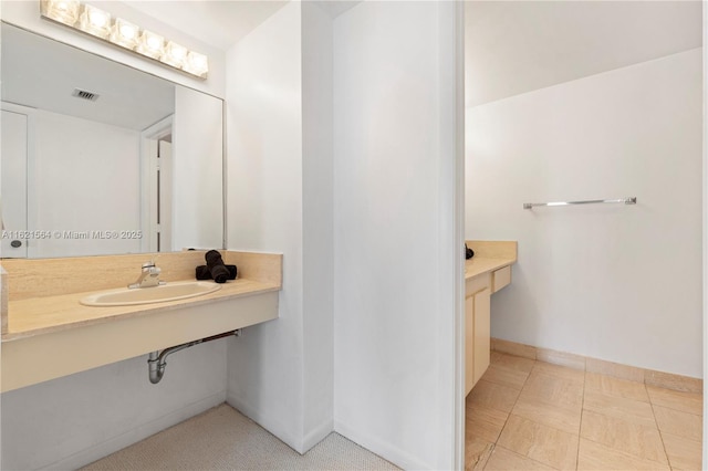 bathroom featuring a sink, visible vents, and baseboards