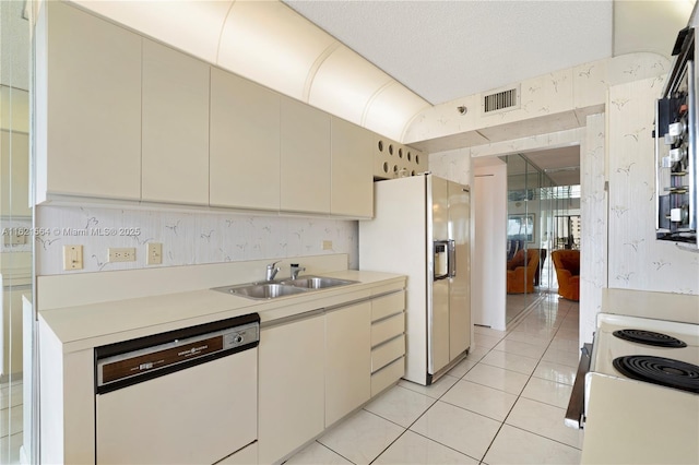 kitchen with white appliances, light countertops, a sink, and light tile patterned flooring