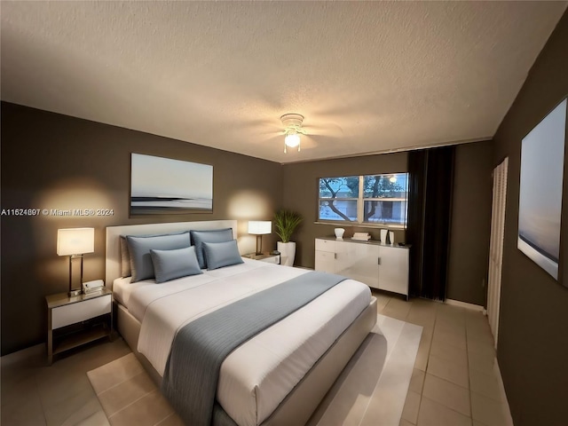 bedroom with a textured ceiling, ceiling fan, and tile patterned flooring