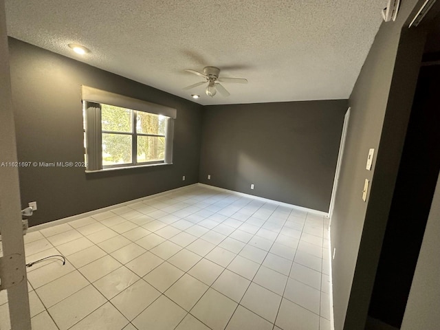 tiled spare room featuring a textured ceiling and ceiling fan