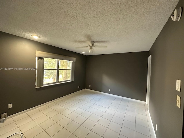 tiled empty room with a textured ceiling and ceiling fan