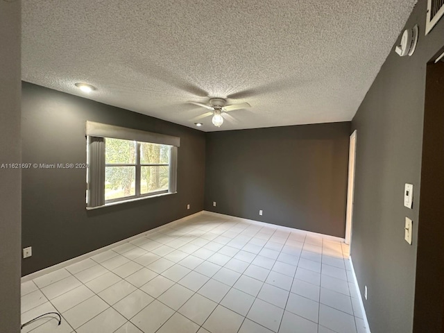 unfurnished room with light tile patterned flooring, a textured ceiling, and ceiling fan