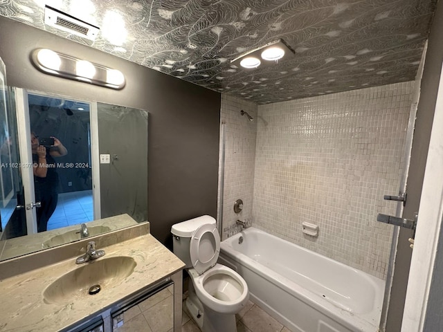 full bathroom featuring tile patterned flooring, tiled shower / bath combo, toilet, and vanity