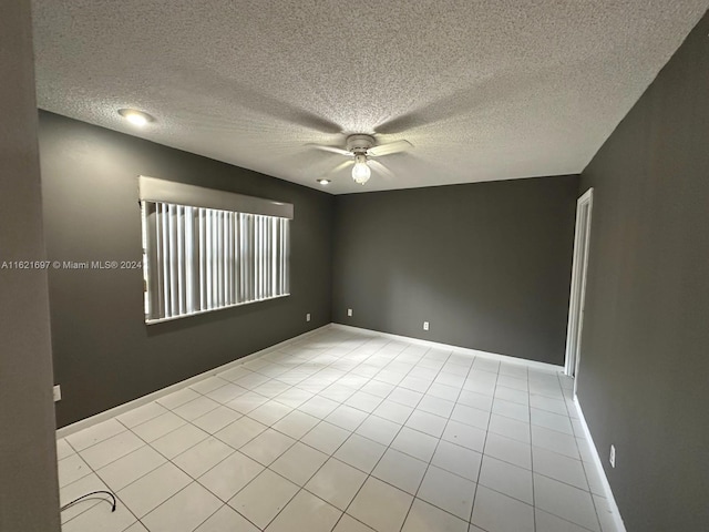 tiled empty room featuring a textured ceiling and ceiling fan